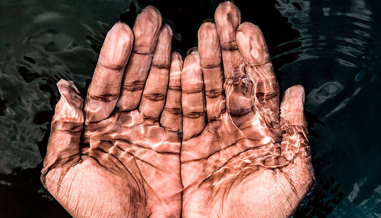 Mani immerse in acqua limpida